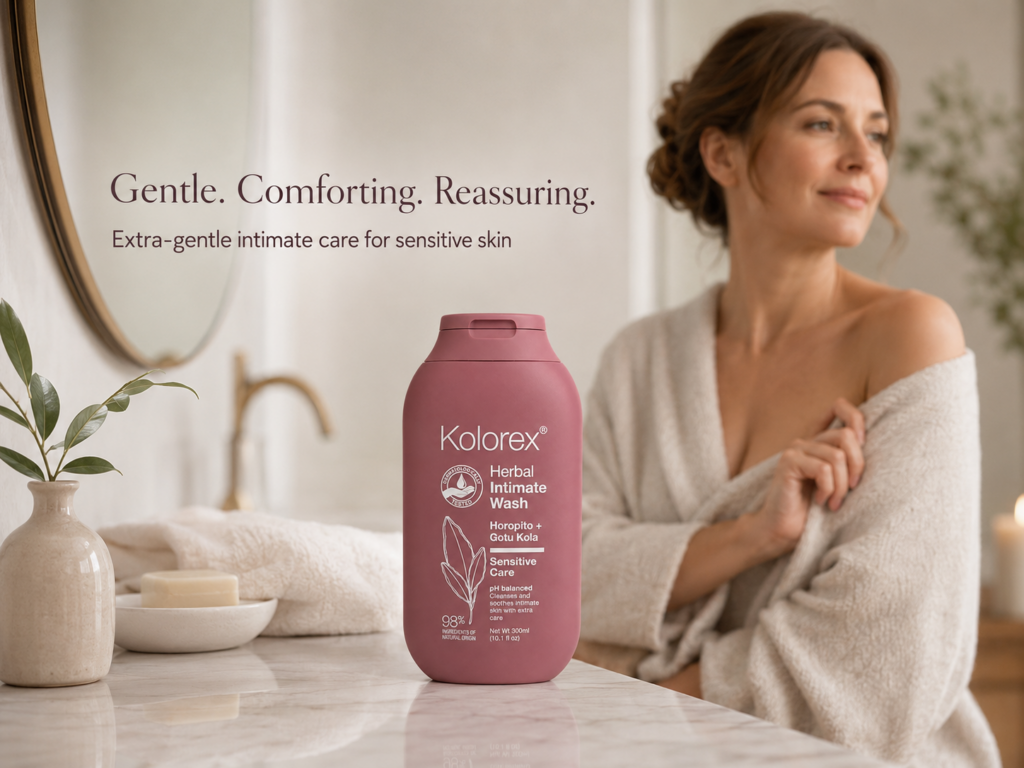 Kolorex Herbal Intimate Wash Sensitive Care on a bathroom counter beside a woman in a robe